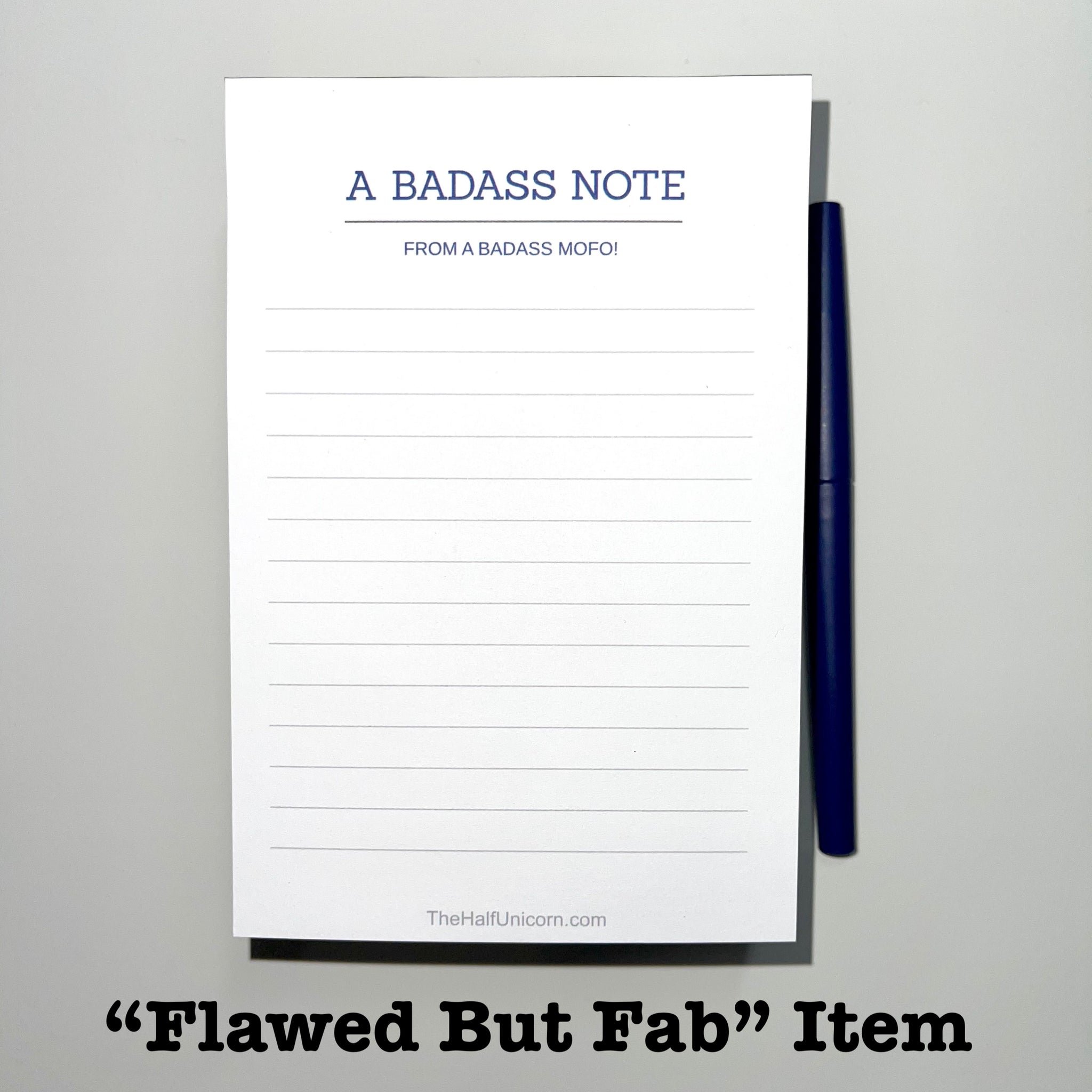 A Badass Note From A Badass Mofo Notepad. Lined white paper with blue lettering.