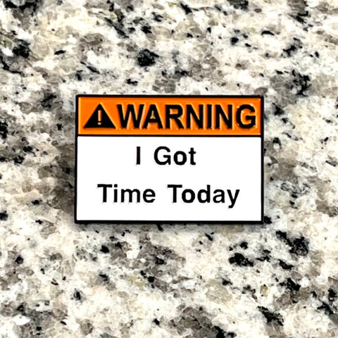 Warning! I Got Time Today enamel pin in traditional orange and white hazard-themed colors. Black lettering: Warning has orange background, I Got Time Today has white background.