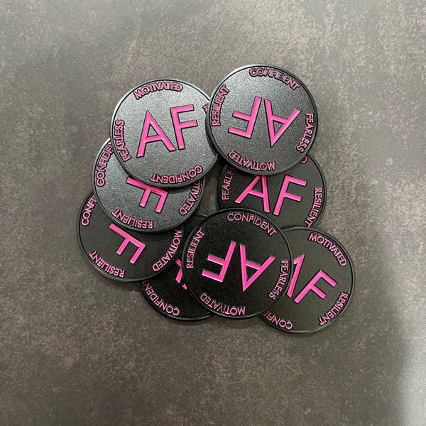 Pile of As F**k Tokens in pink and black colors.