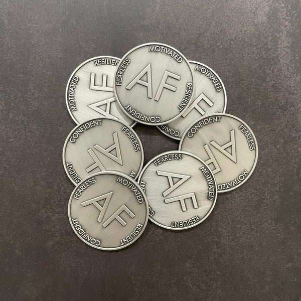 Pile of As F**k Tokens in worn silver color.